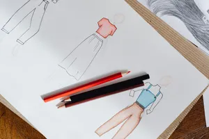 Fashion sketches on paper with red and black colored pencils on a wooden surface. jigsaw puzzle