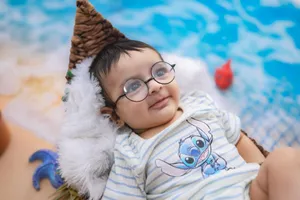 Charming baby in glasses relaxing by the pool in a cute outfit, enjoying the sunny day. jigsaw puzzle