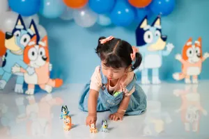 Young girl playing with toy figures at a vibrant, cartoon-themed birthday party jigsaw puzzle