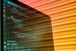 Blurry close-up of a computer screen displaying code with orange lighting. jigsaw puzzle