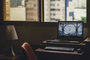 A tranquil home office setup with a laptop, lamp, and city view through the window. jigsaw puzzle
