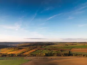 Breathtaking aerial view of rolling fields and wind turbines under a bright blue sky in Germany. jigsaw puzzle