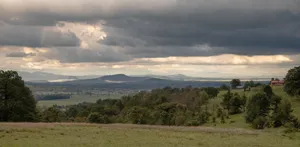 A stunning landscape view showcasing dramatic clouds over a serene Mexican countryside near El Aserrín. jigsaw puzzle