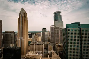 Aerial view of the Minneapolis skyline highlighting its diverse architecture under a cloudy sky. jigsaw puzzle