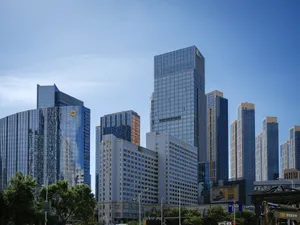 Urban skyline featuring modern skyscrapers with glass facades under a clear blue sky. jigsaw puzzle