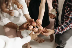Friends gathering, sharing cupcakes indoors, adding sweet charm to their celebration. jigsaw puzzle