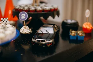 Close-up of a toy car and cupcakes at a race car themed birthday party with vibrant decorations. jigsaw puzzle