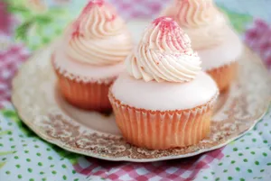 Close-up of pink frosted cupcakes on a vintage plate, perfect for celebrations. jigsaw puzzle