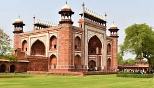 The majestic Great Gate, entrance to Taj Mahal, Agra, with lush green surroundings and tourists. jigsaw puzzle