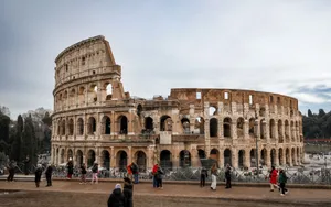 View of the ancient Colosseum in Rome with tourists exploring the historic landmark. jigsaw puzzle