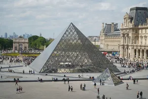 Tourists admire the iconic Louvre Pyramid in Paris, France on a sunny day. jigsaw puzzle