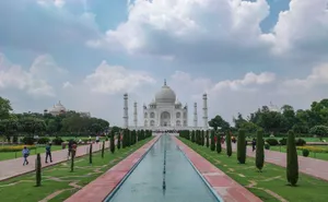 Captivating view of the Taj Mahal with gardens and tourists on a clear day. jigsaw puzzle