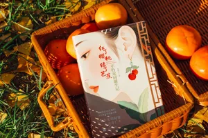A beautifully designed book cover rests in a basket with ripe persimmons, surrounded by autumn leaves. jigsaw puzzle