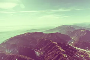 Breathtaking aerial shot capturing the expansive, rugged beauty of a mountain range at twilight. jigsaw puzzle