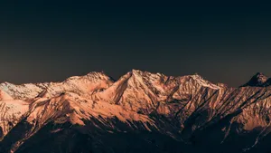 Majestic snow-covered mountains illuminated by sunset, creating a serene and dramatic landscape. jigsaw puzzle