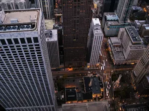 High angle view of a modern city skyline featuring tall skyscrapers and bustling streets at dusk. jigsaw puzzle