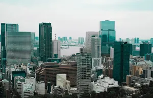 Aerial view of Tokyo's modern skyscrapers with a river backdrop, showcasing urban architecture. jigsaw puzzle
