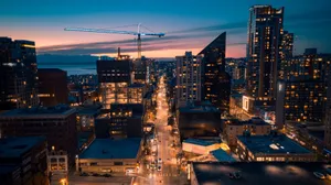 Stunning aerial view of a city skyline at dusk with illuminated streets and buildings. Captured with a drone. jigsaw puzzle