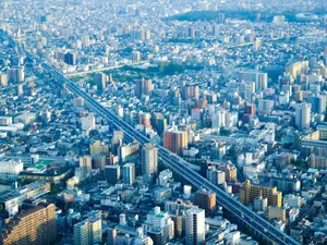Stunning aerial shot of Osaka's densely built urban landscape under a clear blue sky. jigsaw puzzle