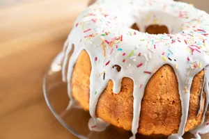 Close-up of a vanilla bundt cake with white icing and colorful sprinkles, perfect dessert treat. jigsaw puzzle