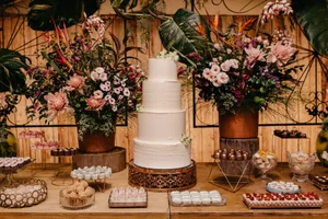 A beautifully decorated wedding dessert table featuring a tiered cake and lavish flower arrangements. jigsaw puzzle