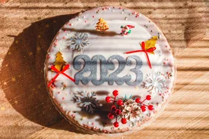 Delicious Christmas cake with 2023 decoration, snowflakes, and festive accents on a brown surface. jigsaw puzzle