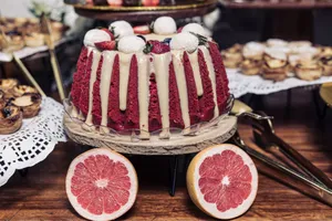 Delicious red velvet cake topped with frosting, strawberries, and grapefruit slices for a festive dessert table. jigsaw puzzle