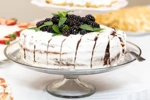 Sliced cake with blackberries and mint on a cake stand, ready to serve. jigsaw puzzle