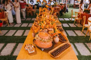 Beautifully adorned wedding table setup with candles, flowers, and desserts in a lush outdoor setting. jigsaw puzzle