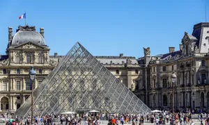 Iconic glass pyramid of Louvre Museum surrounded by tourists on a sunny day in Paris. jigsaw puzzle