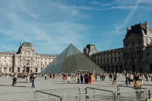 A sunny day at the Louvre with the iconic glass pyramid and crowds of visitors. jigsaw puzzle