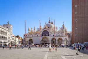 A vibrant scene of Saint Mark's Basilica in Venice, Italy, with people walking in the lively square. jigsaw puzzle