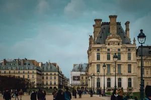 A view of the Louvre Museum's ornate architecture in Paris, bustling with visitors. jigsaw puzzle