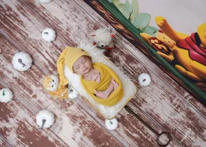 A peaceful sleeping baby wrapped in a yellow outfit surrounded by soft toys and pumpkins. jigsaw puzzle