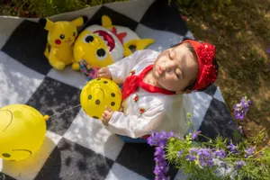 Charming scene of a baby playing with balloons on a picnic blanket surrounded by nature. jigsaw puzzle