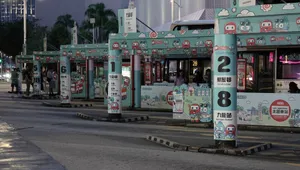 Colorful bus stop scene in Kowloon, Hong Kong, featuring cartoon themed signage and waiting passengers. jigsaw puzzle