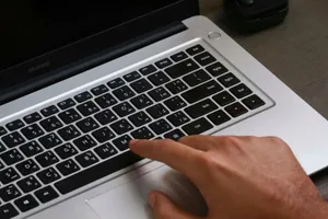 Fingers on a laptop keyboard with Arabic text, showcasing modern technology. jigsaw puzzle