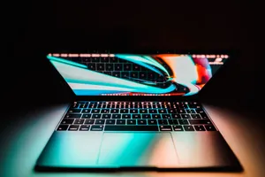 Open laptop with a colorful display reflecting on its keyboard, set against a dark background. jigsaw puzzle