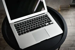A stylish laptop sits elegantly on a black round table in an indoor setting, ideal for tech and workspace themes. jigsaw puzzle