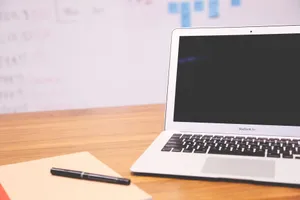 Sleek laptop on wooden desk with pen and notepad, ideal for business and tech settings. jigsaw puzzle