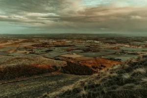 A beautiful aerial landscape photograph of the Scottish countryside with fields and hills under a cloudy sky. jigsaw puzzle