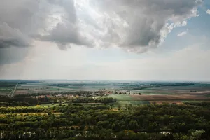 Scenic aerial view of lush countryside with clouds and vibrant fields. jigsaw puzzle