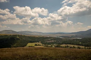 Scenic landscape of Zlatibor Mountains with lush fields and vibrant skies. jigsaw puzzle