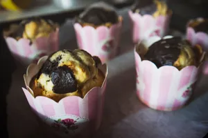 Close-up of homemade muffins with chocolate swirl in pink floral liners, perfect for dessert lovers. jigsaw puzzle