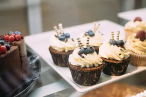 Tempting cupcakes topped with blueberries and chocolate icing on display tray. jigsaw puzzle
