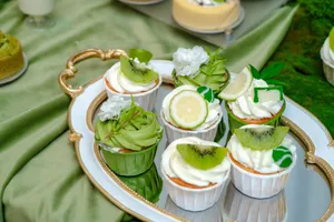 A delightful display of kiwi and lemon cupcakes beautifully arranged on a vintage silver tray. jigsaw puzzle