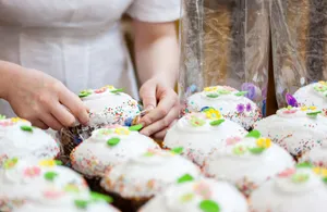 Crop anonymous female confectioner preparing Easter cakes decorated with colorful sprinkles and sweet glaze jigsaw puzzle