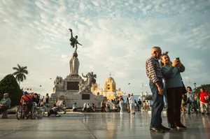 Tourists capture a selfie at Plaza de Armas in Trujillo, Peru, with vibrant city life in the background. jigsaw puzzle