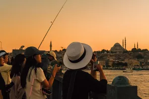 Tourists photograph the stunning Istanbul skyline at sunset from a bridge, capturing the city's vibrant atmosphere. jigsaw puzzle