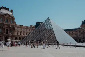 Visitors at the iconic Louvre Pyramid in Paris, enjoying a sunny day outside the famous museum. jigsaw puzzle